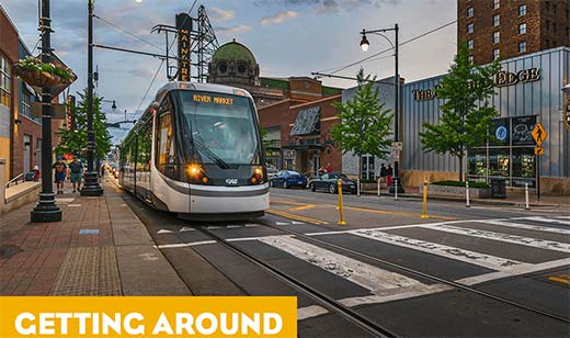 The Kansas City Streetcar moving by the Power & Light District - the tagline reads: Getting Around With Ease